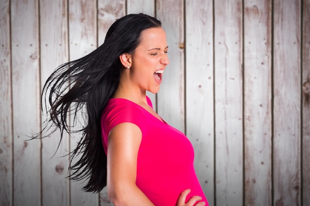 Young brunette singing in tshirt against wooden planks