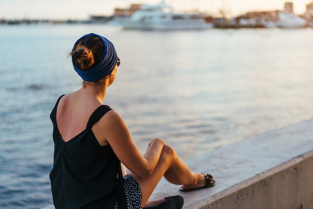 Young brunette tourist girl relaxing near sea