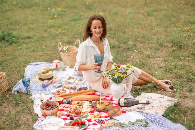 Young brunette woman enjoy outdoor picnic on green lawn.