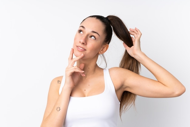 Young brunette woman over isolated white wall . Portrait