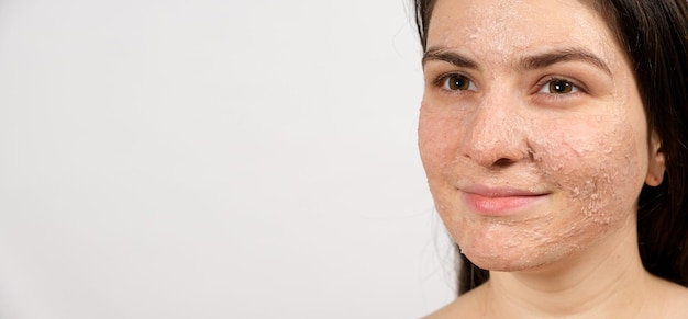 A young brunette woman makes cleansing facial treatments