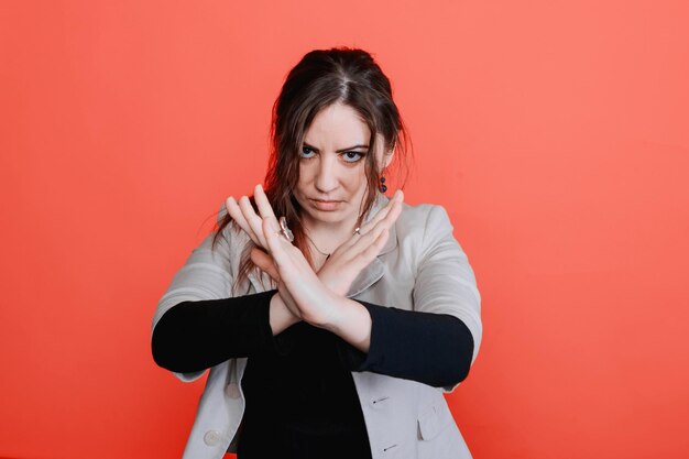 Photo young brunette woman shows no gesture red background