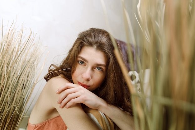 Young brunette woman sitting and touching her shoulder, selective focus