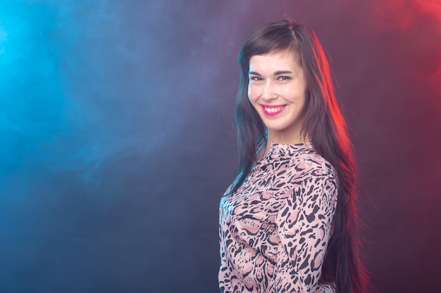 Young brunette woman standing against a colourful wall with copy space