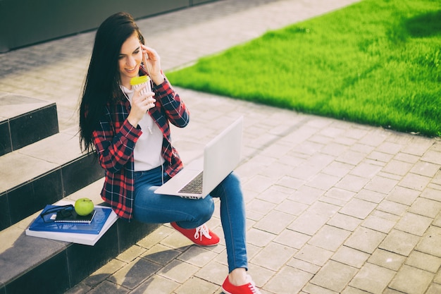 Young brunette woman student working outdoors