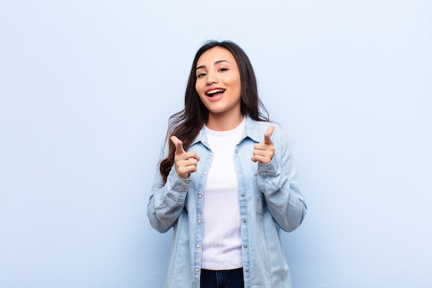 young brunette woman with a happy attitude pointing forwards