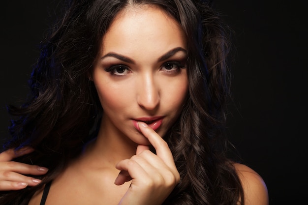 Young brunette woman with long black curly hair, close up