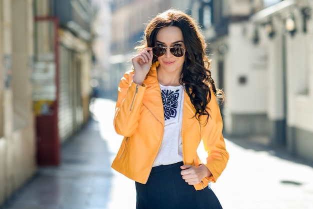 Young brunette woman with sunglasses in urban background