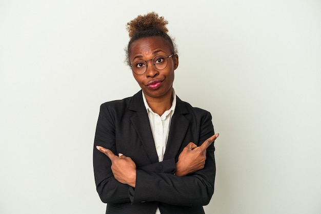 Young business african american woman isolated on white background points sideways, is trying to choose between two options.