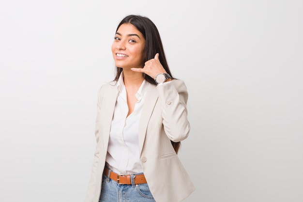 Young business arab woman isolated against a white  showing a mobile phone call gesture with fingers.