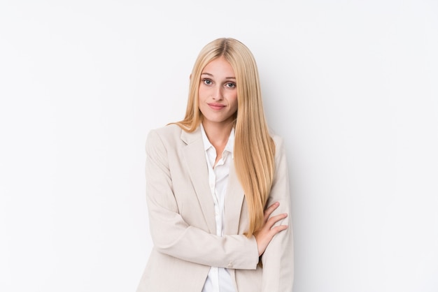 Young business blonde woman on white wall unhappy looking in camera with sarcastic expression.