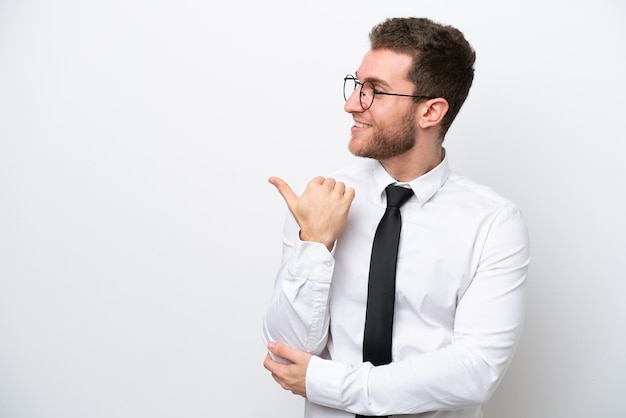 Young business caucasian man isolated on white background pointing to the side to present a product