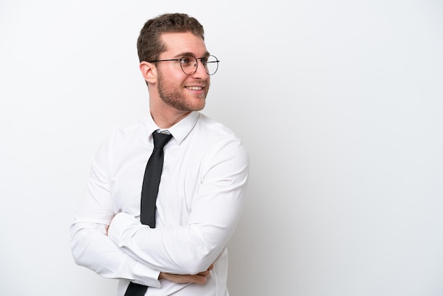 Young business caucasian man isolated on white background with arms crossed and happy