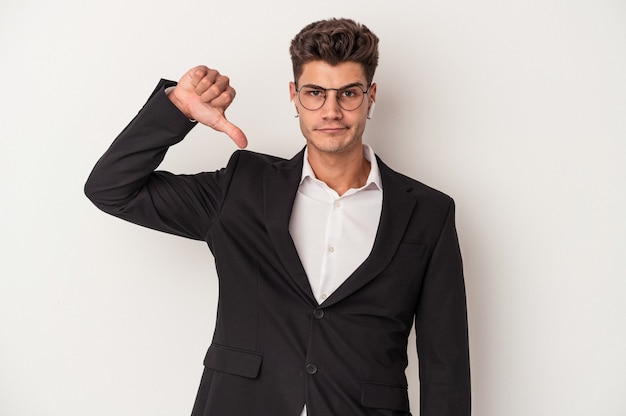 Young business caucasian man wearing headphones isolated on white background showing a dislike gesture, thumbs down. Disagreement concept.