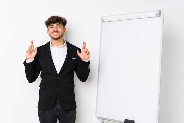 Young business coaching arabian man crossing fingers for having luck