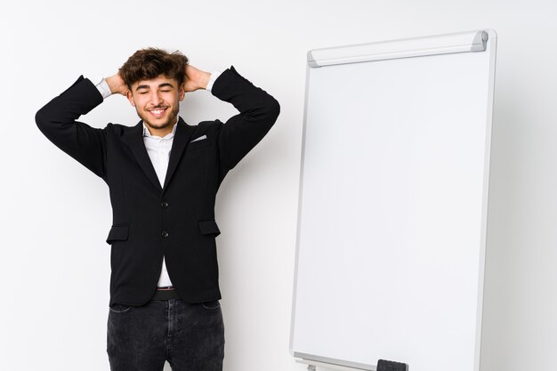 Young business coaching ian man laughs joyfully keeping hands on head