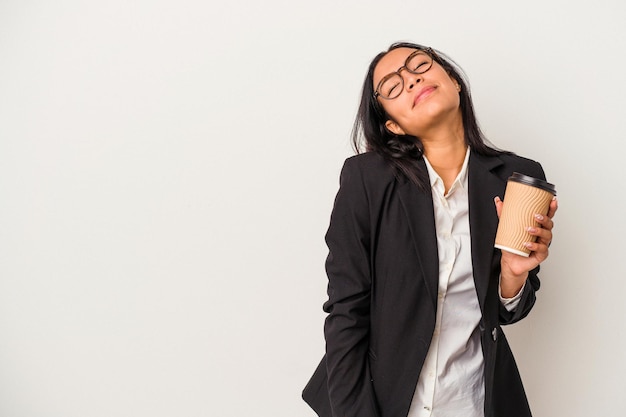 Young business latin woman holding a take away coffee isolated on white background  dreaming of achieving goals and purposes