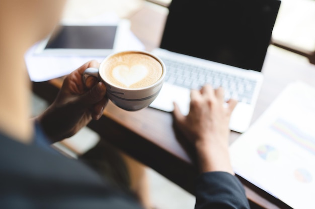 Young business man and entrepreneur drinking drinking coffee and working on laptop in office