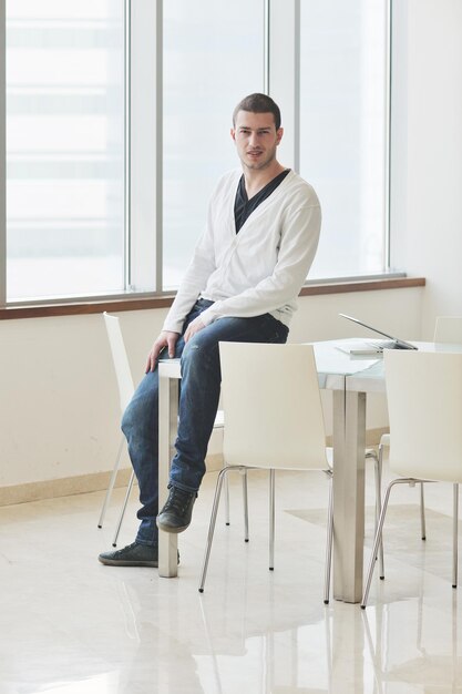 young business man lawyer with laptop alone in big bright   conference room