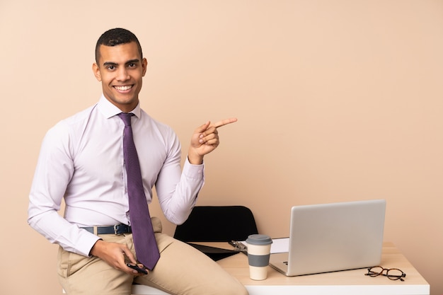 Young business man in a office pointing finger to the side