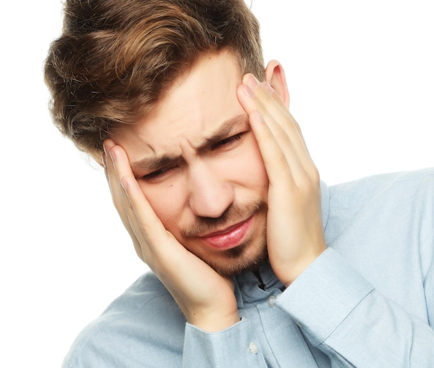 Young business man touching his head and keeping eyes closed