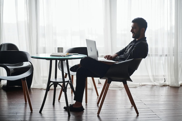 Young business man working on a laptop while sitting at a coffee table