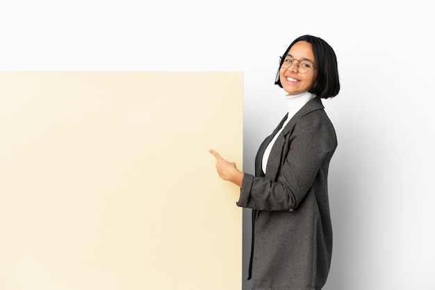 Young business mixed race woman with with a big banner over isolated background pointing back