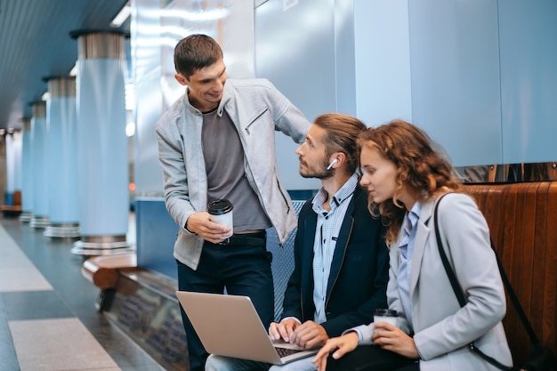 young business people discussing work issues on the subway platform 