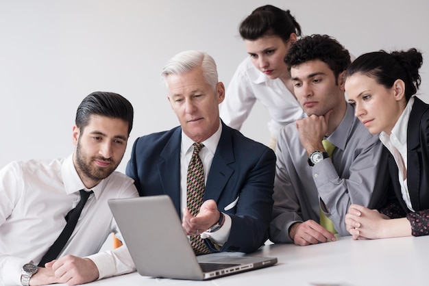 Young business people group on meeting at modern startup office with  senior manager.  Team leader looking presentation and  results  on tablet and laptop computer.