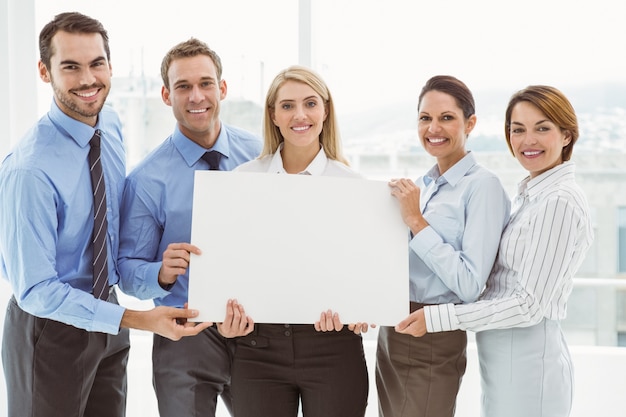 Photo young business people holding blank board in office