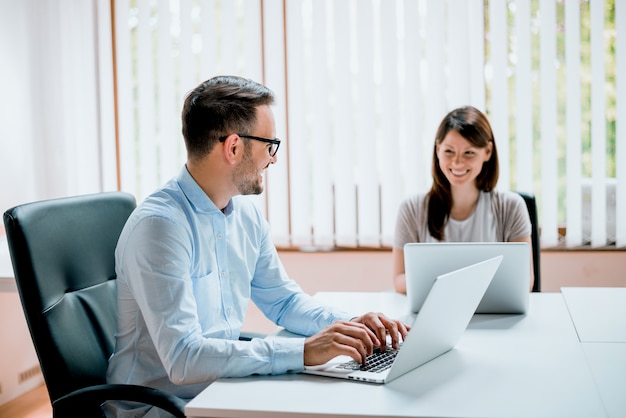 Young business people working in the office looking at each other.