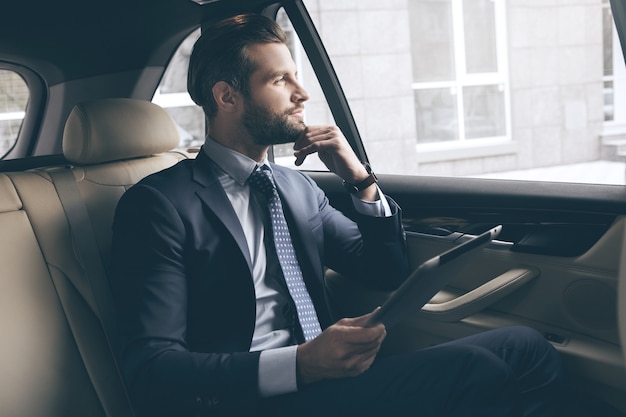 Young business person test drive new vehicle usng digital device