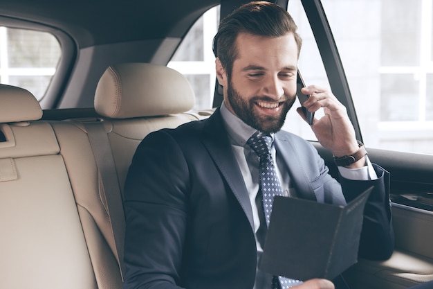 Young business person test drive new vehicle usng digital device