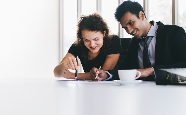 Young business team happy discussing on data sheets on desk while small meeting