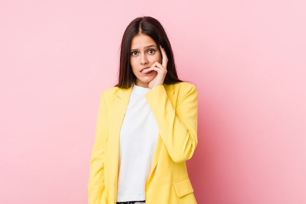 Young business woman biting fingernails, nervous and very anxious.