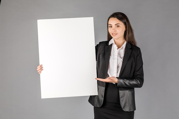 Young business woman in dark suite on grey background Office concept