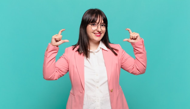 young business woman framing or outlining own smile with both hands, looking positive and happy, wellness concept