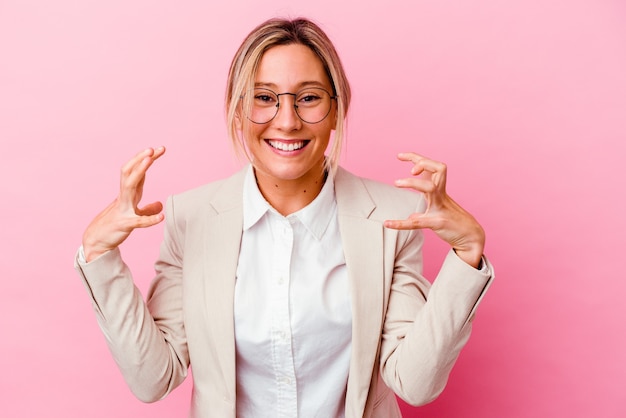 Young business woman isolated on pink wall upset screaming with tense hands