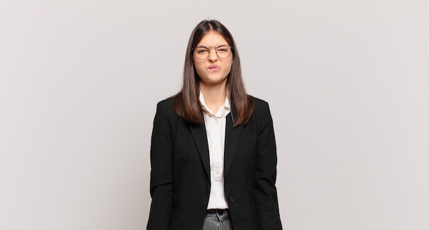 Young business woman looking goofy and funny with a silly cross-eyed expression, joking and fooling around