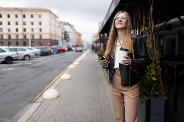 Young business woman on the phone in her hands and a cup of coffee