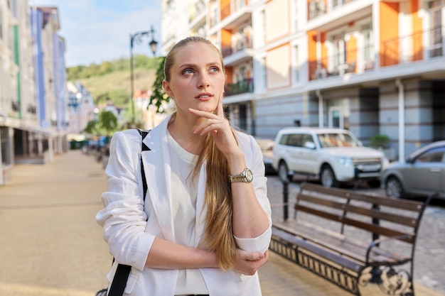 Young business woman recording stream in city. Beautiful confident professional female journalist talking gesturing looking at webcam. Business project presentation, remote work, interview