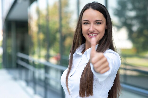 Photo young business woman shows thumb up