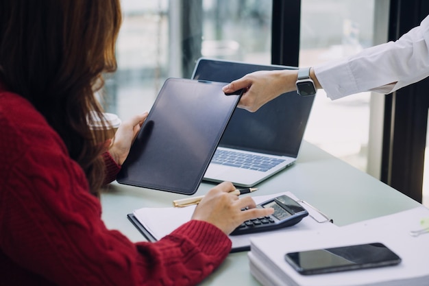 Young business woman sitting in office at table and using smartphone On desk is laptop and tablet computer on screen charts and graphs Woman analyzing data Student learning online