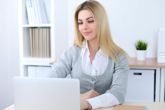 Young business woman or student girl sitting at office workplace with laptop computer Home business concept