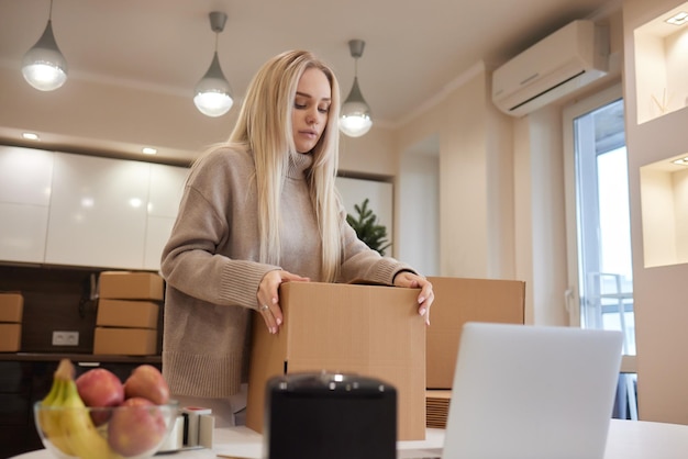 Young business woman taping up a cardboard box in the office relocation and new business concept