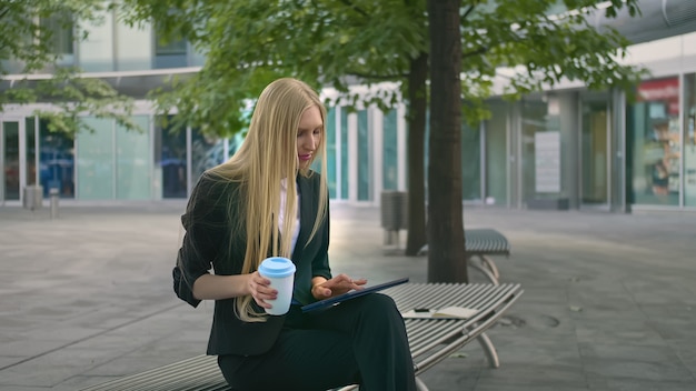 Young business woman using tablet and drinking coffee.