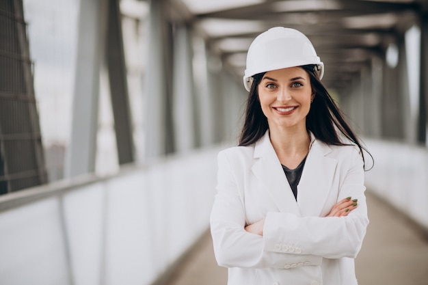 Young business woman wearing hard hat at building object