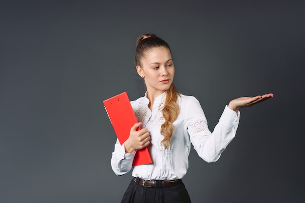 Young business woman in a white shirt and with a folder