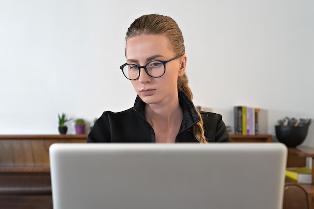 Young business woman with eyeglasses teacher in front of laptop