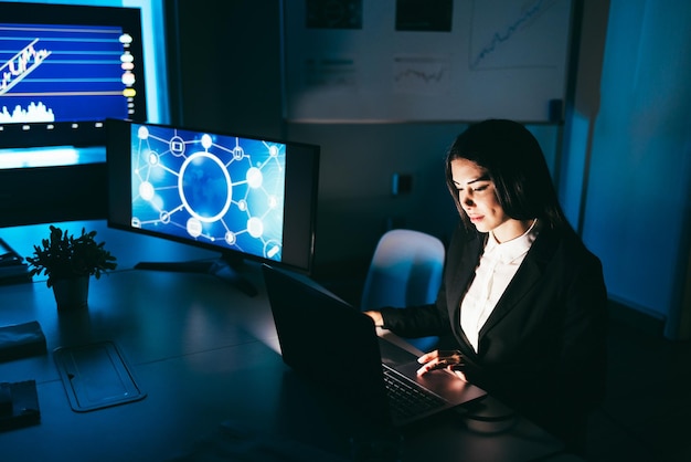 Young business woman working at night inside fintech company office doing blockchain research  Focus on face